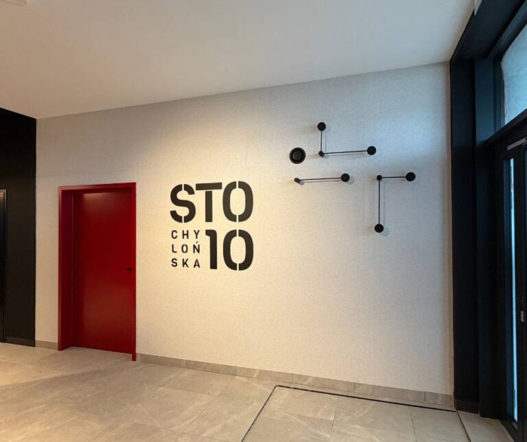 STO10 CHYLOŃSKA 3 etap wejście do budynku - oznaczenie inwestycji w lobby